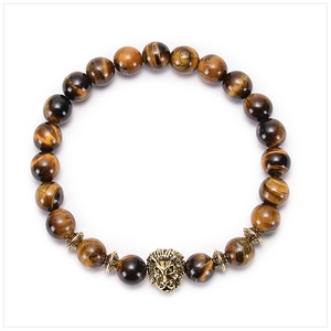 Macro detail of natural tiger eye stone beads and an intricate alloy lion head charm