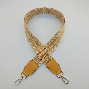 Detail of adjustable woven wide strap in yellow and white stripes with gold hardware