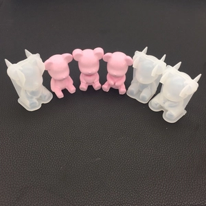 Three styles of DIY silicone bear molds with finished pink resin crafts on black texture
