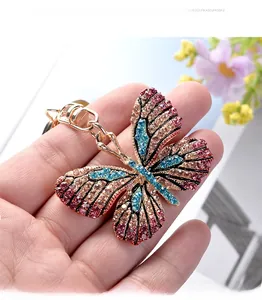 Detail of colorful rhinestone butterfly keychain with gold spring clasp in hand