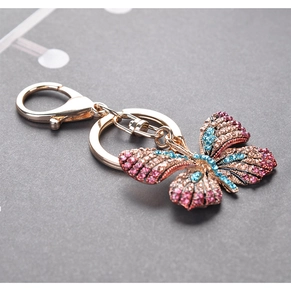 Detail of butterfly keychain with pink and blue rhinestones on light gold alloy metal