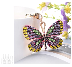 Detailed close-up of a golden butterfly keychain encrusted with vibrant colorful crystals