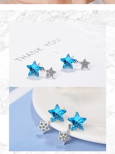 Macro shot of blue crystal star and silver pavé star earrings on white background
