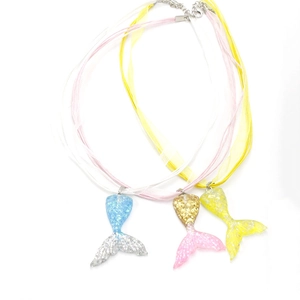 Detailed view of colorful gradient mermaid tail pendants with shimmering glitter texture