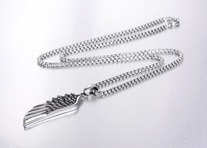 Detailed macro view of a silver wing pendant with a sturdy metal box chain necklace