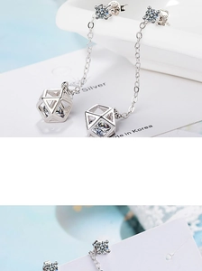 Macro shot of silver geometric cube drop earrings with sparkling zirconia crystals