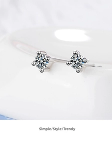 Macro shot of silver four-claw earrings with round brilliant-cut sparkling cubic zirconia