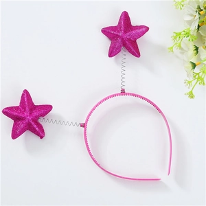 Close-up of pink headband with glittery star decorations on spring attachments
