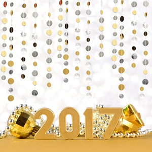 Close-up of golden 2017 3D numbers with festive glitter stars and hanging party garlands