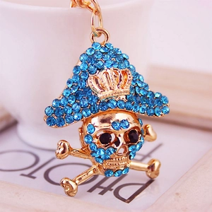 Golden pirate skull keychain with sparkling blue rhinestones and crown detail