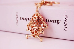 Close-up of golden mushroom keychain with hollow heart pattern and pink rhinestones