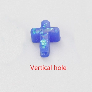 Macro view of blue synthetic opal cross bead with vertical hole and fiery luster