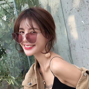 Detail of pink gradient cat-eye sunglasses with slim golden metal frame on female model