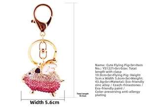 Macro view of flying pig keychain with pink rhinestones and white enamel wings detail