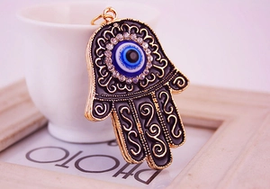 Detail of Hamsa Hand keychain with black enamel, evil eye, and sparkling rhinestones