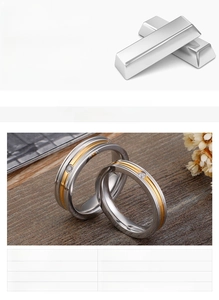Detail of two-tone stainless steel ring with a small zircon on a rustic wooden background