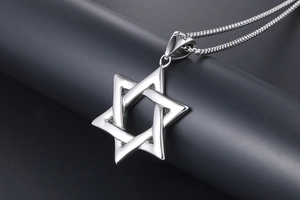 Macro shot of silver hollow hexagram star pendant in polished stainless steel for men
