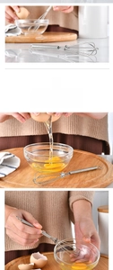 Close-up of mini stainless steel whisk with spring handle mixing egg in a bowl