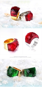 Detail of faceted red and green crystal rings with 18K gold plated settings on lace