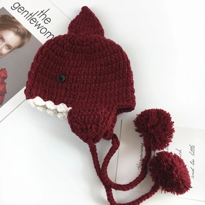 Dettaglio cappello in maglia a squalo per bimbi con pinne carine e pompon rossi morbidi