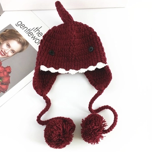 Dettaglio del cappello in maglia a squalo bordeaux per neonati con paraorecchie e pompon