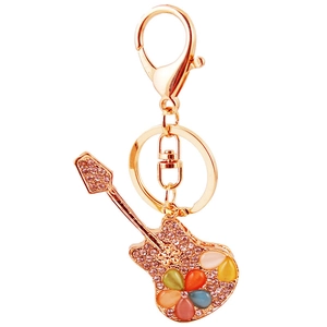 Golden guitar keychain with pink rhinestones and colorful gemstone flower charm