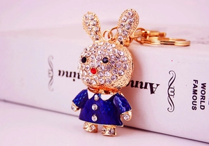 Detail of a rabbit keychain with clear crystals and a dark blue enamel dress finish