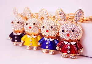 Detail of four colorful rhinestone rabbit keychains in gold finish with crystal accents