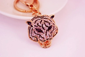 Close-up of rose gold leopard keychain with sparkling white and black rhinestones