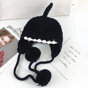 Dettaglio cappello a maglia squalo nero con pinne 3D, denti e morbidi pompon neri