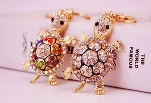 Macro view of crystal turtle keychains with colorful and clear rhinestones on gold metal