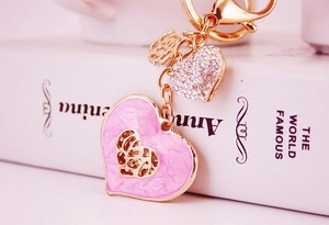 Detail of pink enamel heart keychain with rhinestones on a decorative book