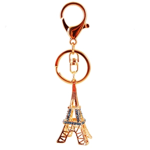 Porte-clés Tour Eiffel doré avec strass bleus et fermoir mousqueton sur fond blanc