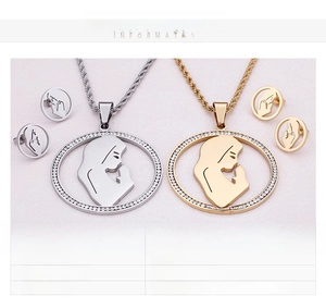 Close-up of religious pendant earrings set with rhinestones and hollow silhouette