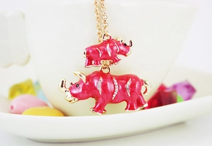 Detailed close-up of golden rhino charm with red enamel and sparkling crystal inlay