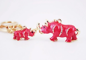 Detail of red enamel mother and baby rhinoceros keychain with rhinestones and gold plating