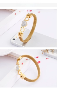 Detail of gold mesh heart bracelet featuring white zirconia stones and Milanese band style