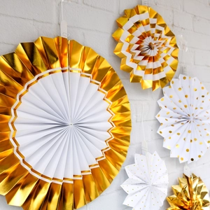 Elegant gold and white paper fan set decorations for wedding party hanging on wall