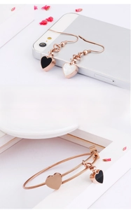 Detail of rose gold heart earrings and bangle set with black and white inlay textures