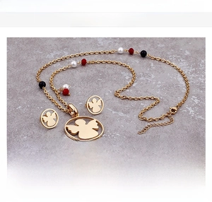 Detail view of gold titanium steel angel jewelry set with necklace and earrings
