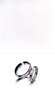 Détails des bagues en acier montrant l'anneau noir 6mm et or rose 4mm avec zircon