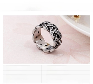 Detail of woven stainless steel ring with white pavé zircons and steel finish