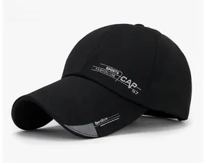 Detail shot of black sports baseball cap with long visor and embroidered white lettering