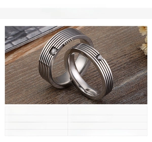 Detail view of steel ring featuring parallel grooves and a single sparkling crystal