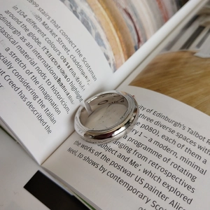 Close-up of polished S925 sterling silver open ring on a vintage book page