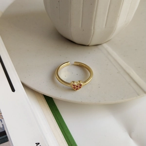 Detail of 925 silver gold ring featuring a heart set with red stones and S925 hallmark