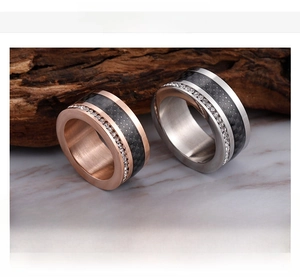 Detail of stainless steel rings with black carbon fiber inlay and small crystals
