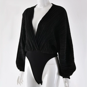 Detail of black V-neck bodysuit showing pleated fabric texture and long loose sleeves