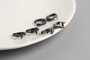 Detailed view of black S925 sterling silver hoop earrings with cross pendants on a tray