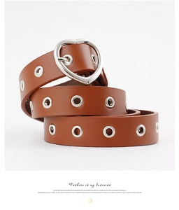 Detail of a brown leather belt with silver metal eyelets and a heart-shaped buckle